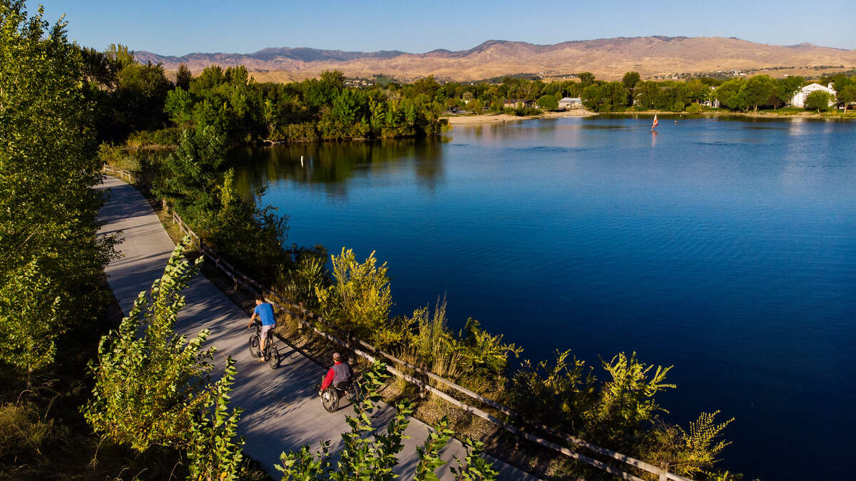 A person using a bicycle and a person using a wheelchair travel along the Greenbelt by Quinn’s Pond in Garden City on Sept. 24, 2022. A person using a bicycle and a person using a wheelchair travel along the Greenbelt by Quinn’s Pond in Garden City on Sept. 24, 2022.